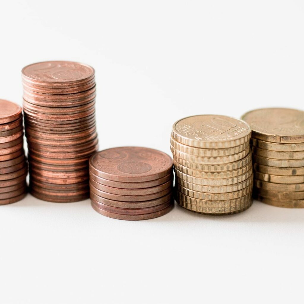 stacked round gold-colored coins on white surface
