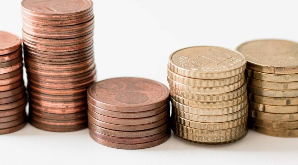 stacked round gold-colored coins on white surface
