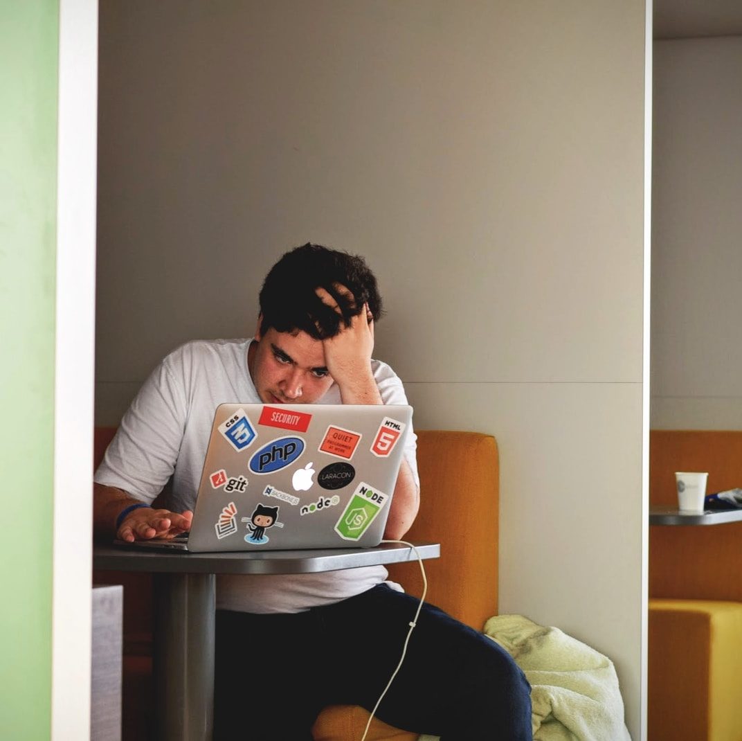 man wearing white top using MacBook