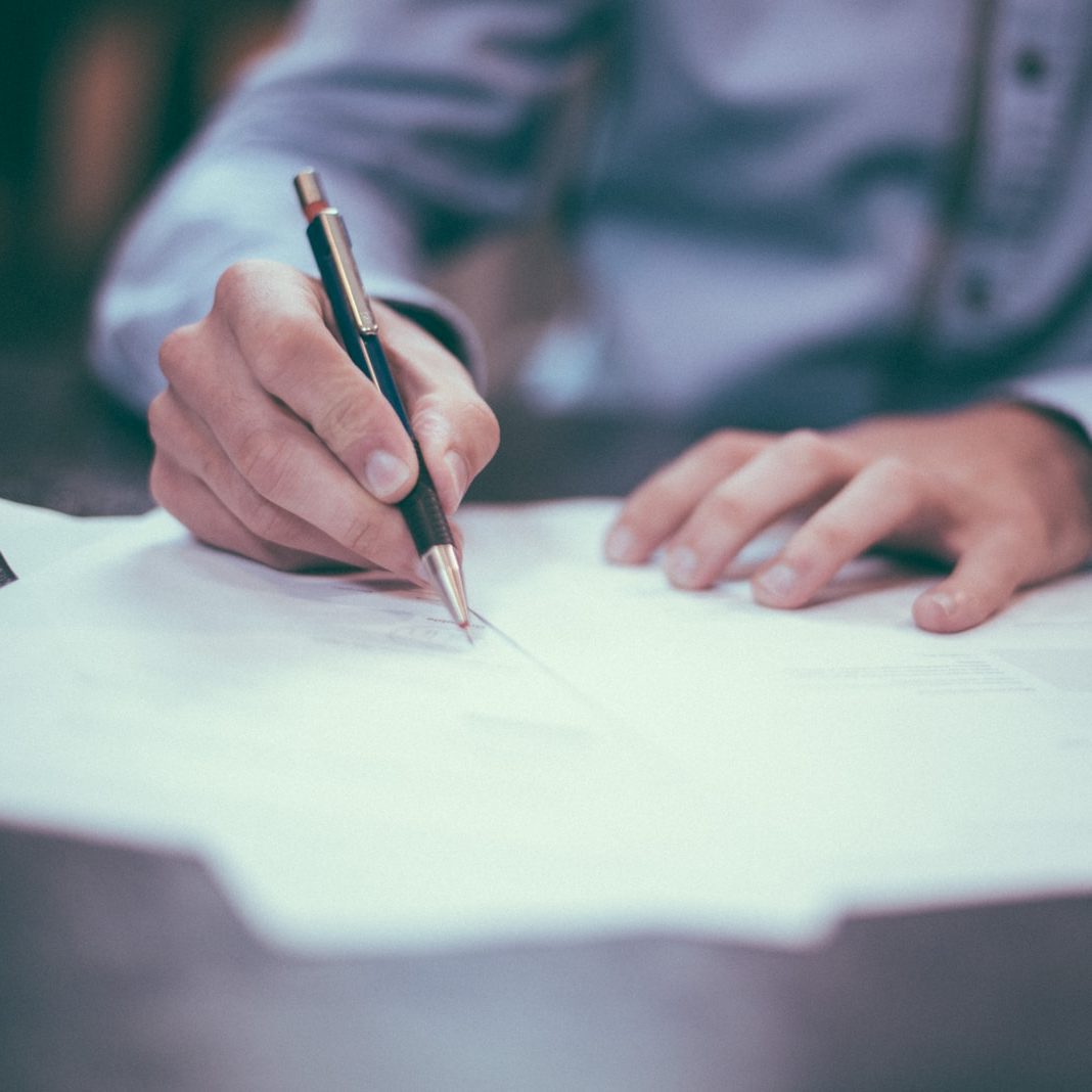 man writing on paper